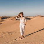 elegante-belle-femme-marchant-dans-sable-du-desert-tenue-blanche-portant-chapeau-paille-coucher-du-soleil